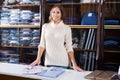 Young female seller demonstrating shirts in menÃ¢â¬â¢s cloths store